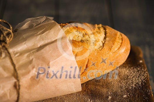A fresh baguette on a wooden surface. Shallow depth of field. A fresh baguette on a wooden surface. Shallow depth of field.
