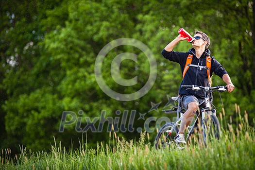 Handsome young man biking in the countryside Handsome young man biking in the countryside