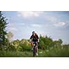 Handsome young man biking in the countryside