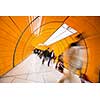 People rushing through a subway corridor (motion blur technique is used to convey movement)