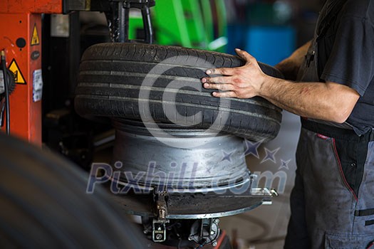 Tyre change - wheel balancing or repair and change car tire at auto service garage or workshop by mechanic Tyre change - wheel balancing or repair and change car tire at auto service garage or workshop by mechanic