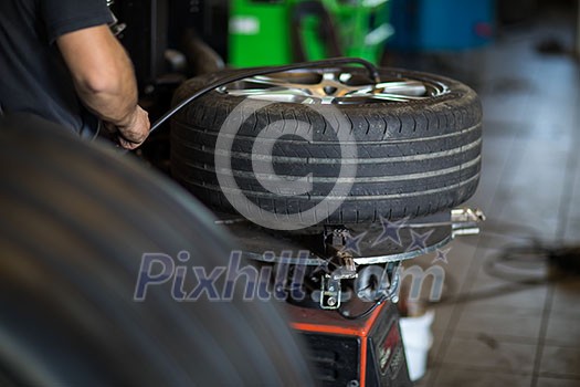 Tyre change - wheel balancing or repair and change car tire at auto service garage or workshop by mechanic Tyre change - wheel balancing or repair and change car tire at auto service garage or workshop by mechanic