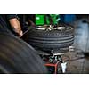 Tyre change - wheel balancing or repair and change car tire at auto service garage or workshop by mechanic
