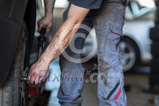 Wheel balancing or repair and change car tire at auto service garage or workshop by mechanic Wheel balancing or repair and change car tire at auto service garage or workshop by mechanic
