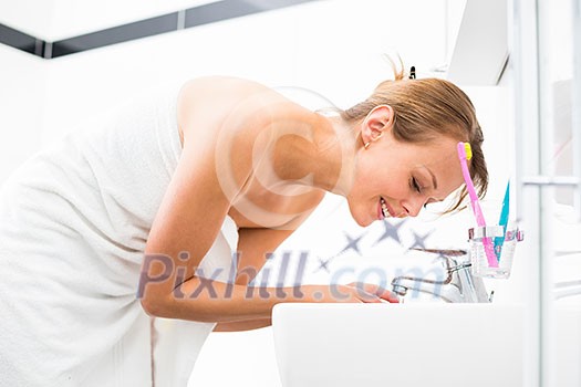 Pretty female brushing her teeth in front of mirror in the morning Pretty female brushing her teeth in front of mirror in the morning