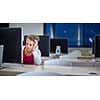 Pretty, young female college student using a desktop computer/pc in a college library (shallow DOF; color toned image)