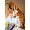 Pretty young woman  choosing the right material/color for her modern appartement interior (shallow DOF; color toned image)