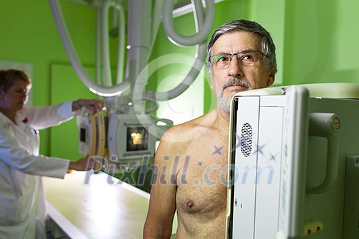 Healthcare Concept - Senior male patient undergoing an X-ray examination in a modern hospital Healthcare Concept - Senior male patient undergoing an X-ray examination in a modern hospital