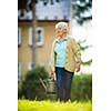 Senior woman doing some gardening in her lovely garden - watering the plants