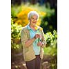 Senior woman doing some gardening in her lovely garden - watering the plants