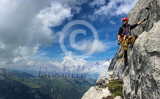 Young man climbing on a rock in Swiss Alps - via ferrata/klettersteig