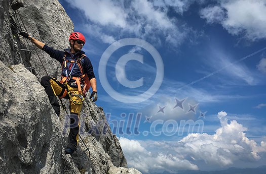 Young man climbing on a rock in Swiss Alps - via ferrata/klettersteig Young man climbing on a rock in Swiss Alps - via ferrata/klettersteig
