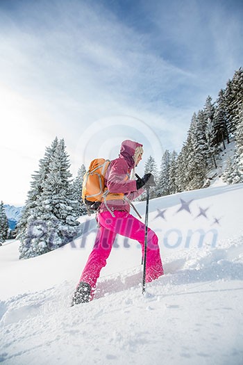Pretty, young woman snowshoeing in high mountains, enjoying splendid winter weather with abundance of snow Pretty, young woman snowshoeing in high mountains, enjoying splendid winter weather with abundance of snow