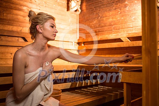 Young woman relaxing in a sauna Young woman relaxing in a sauna