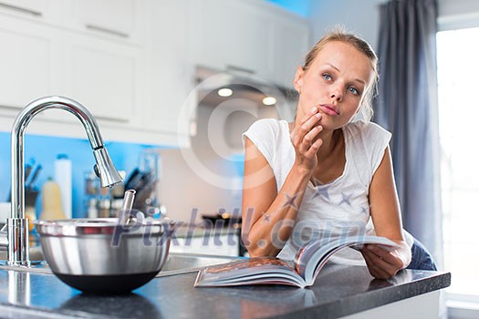 Pretty, young woman in her modern, clean and bright kitchen, fixing lunch (color toned imagey; shallow DOF) Pretty, young woman in her modern, clean and bright kitchen, fixing lunch (color toned imagey; shallow DOF)