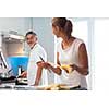 Senior man cooking in a bright modern kitchen together with his daughter, having a blast (color toned image)