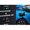 Power supply for electric car charging. Electric car charging station. Close up of the power supply plugged into an electric car being charged.