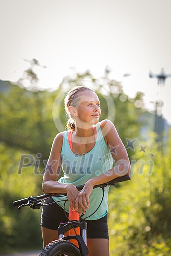 Pretty, young woman biking on a mountain bike enjoying healthy active lifestyle outdoors in summer (shallow DOF) Pretty, young woman biking on a mountain bike enjoying healthy active lifestyle outdoors in summer (shallow DOF)