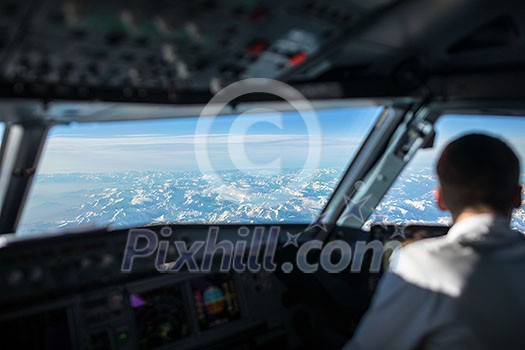 Pilot in a commercial airliner airplane flight cockpit during flight with great weather Pilot in a commercial airliner airplane flight cockpit during flight with great weather