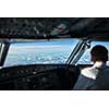 Pilot in  a commercial airliner airplane flight cockpit during flight with great weather
