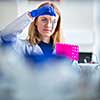 Portrait of a female researcher doing research in a lab (shallow DOF; color toned image)