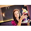 Cute young woman in an ice cream parlor, taking her ice-cream from the counter