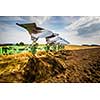 Tractor working on the farm, modern agricultural transport, farmer working in the field, tractor on a sunset background, cultivation of land, agricultural machine (motion blurred image)