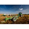 Tractor working on the farm, modern agricultural transport, farmer working in the field, tractor on a sunset background, cultivation of land, agricultural machine