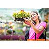 Young woman buying flowers at a garden center