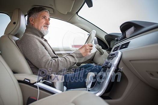 Senior man driving his modern car, going in reverse, watching out not to hit anything or anyone (color toned image; shallow DOF) Senior man driving his modern car, going in reverse, watching out not to hit anything or anyone (color toned image; shallow DOF)