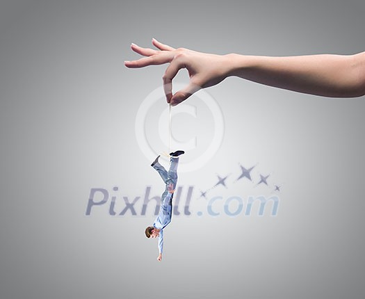 Close up of human hand holding miniature of businessman Close up of human hand holding miniature of businessman