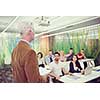 group of students study with professor in modern school classroom