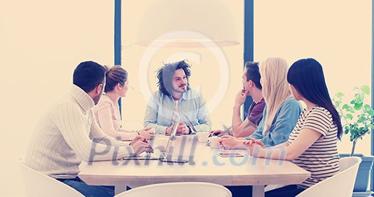 Group of a young business people discussing business plan at modern startup office building Group of a young business people discussing business plan at modern startup office building