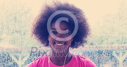portrait of young afro american woman in gym on workout break while listening music on earphone and dancing rainy day and bad weather outdooor portrait of young afro american woman in gym on workout break while listening music on earphone and dancing rainy day and bad weather outdooor