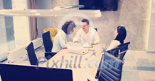 Group of a young business people discussing business plan at modern startup office building Group of a young business people discussing business plan at modern startup office building