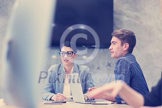 Group of a young business people discussing business plan at modern startup office building Group of a young business people discussing business plan at modern startup office building