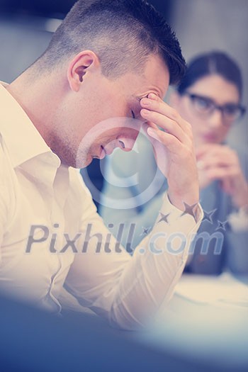 A time for relax. Young tired casual businessman relaxing at the desk in his office A time for relax. Young tired casual businessman relaxing at the desk in his office