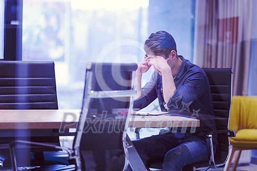 A time for relax. Young tired casual businessman relaxing at the desk in his office A time for relax. Young tired casual businessman relaxing at the desk in his office