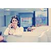 young smiling female call centre operator doing her job with a headset