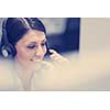 young smiling female call centre operator doing her job with a headset