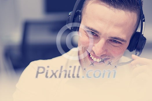 young smiling male call centre operator doing his job with a headset young smiling male call centre operator doing his job with a headset