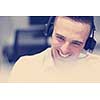 young smiling male call centre operator doing his job with a headset