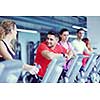 group of young people running on treadmills in modern sport  gym