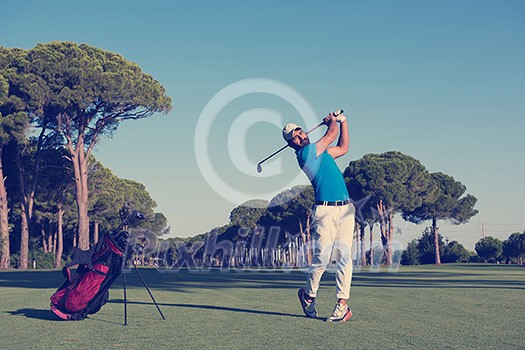 golf player hitting shot with driver on course at beautiful sunny day golf player hitting shot with driver on course at beautiful sunny day