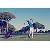 golf player hitting shot with driver on course at beautiful sunny day