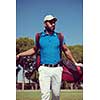 handsome middle eastern golf player carrying  bag  and walking at course to next hole