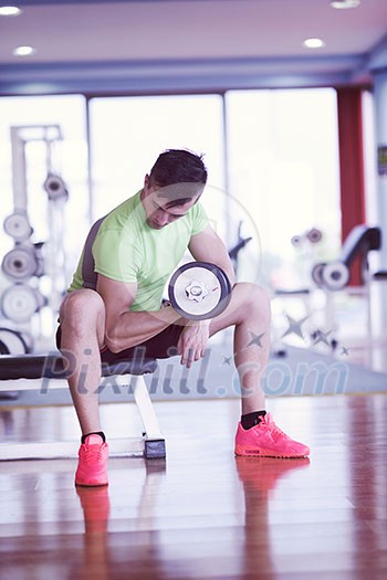young handsome man working out with dumbbells in a fitness gym young handsome man working out with dumbbells in a fitness gym