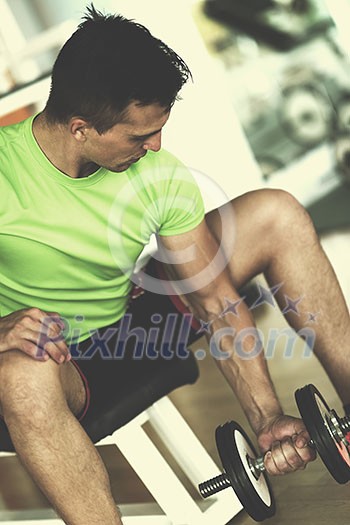 young handsome man working out with dumbbells in a fitness gym young handsome man working out with dumbbells in a fitness gym