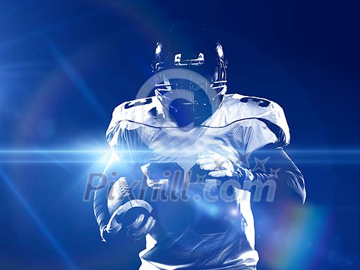portrait of confident American football player holding ball while standing on field at night portrait of confident American football player holding ball while standing on field at night