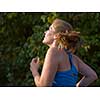 young woman enjoying in a healthy lifestyle while jogging along a country road, exercise and fitness concept